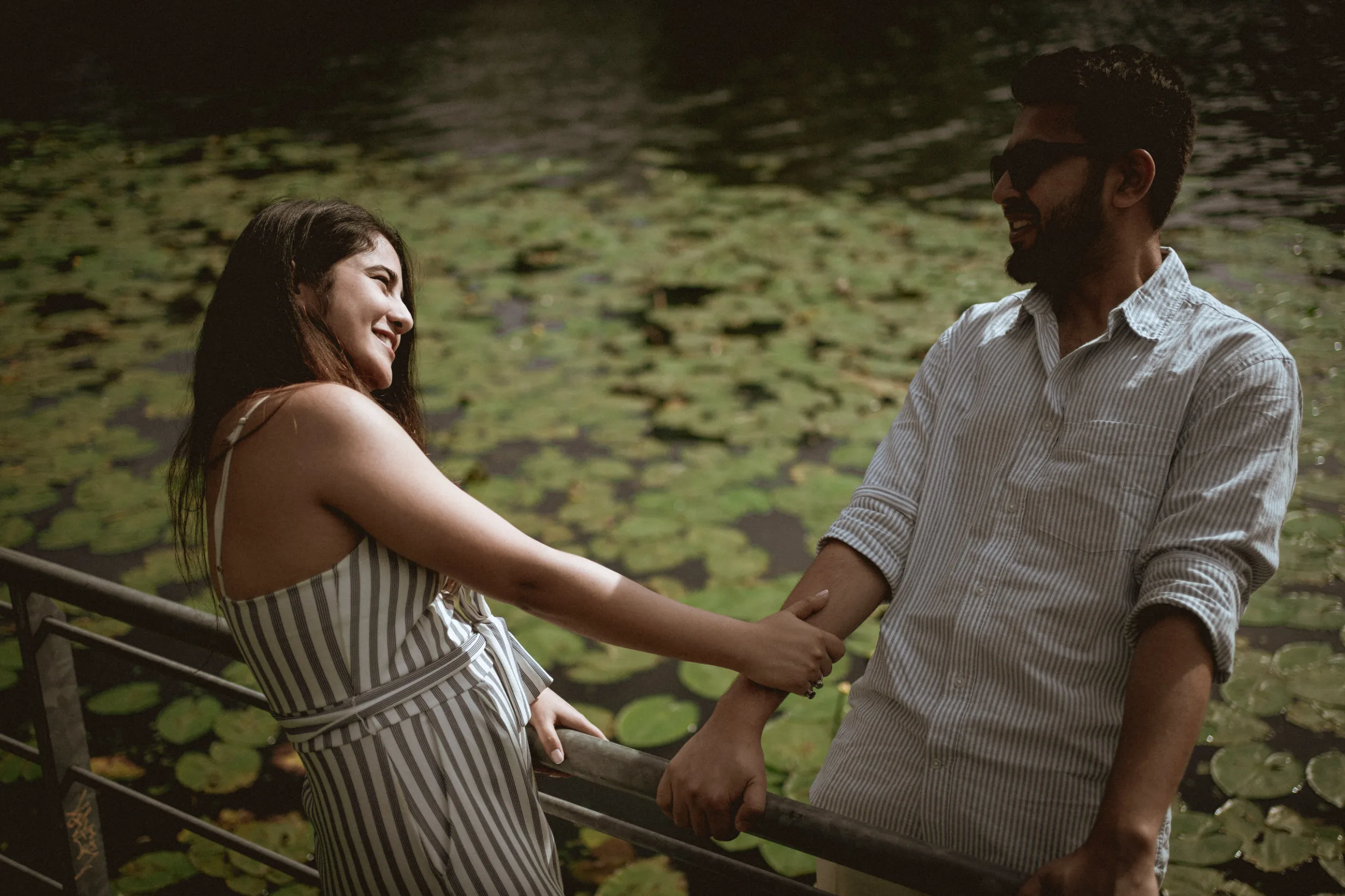 Couple looking at each other next to water in Treptower park in Berlin on a sunny day