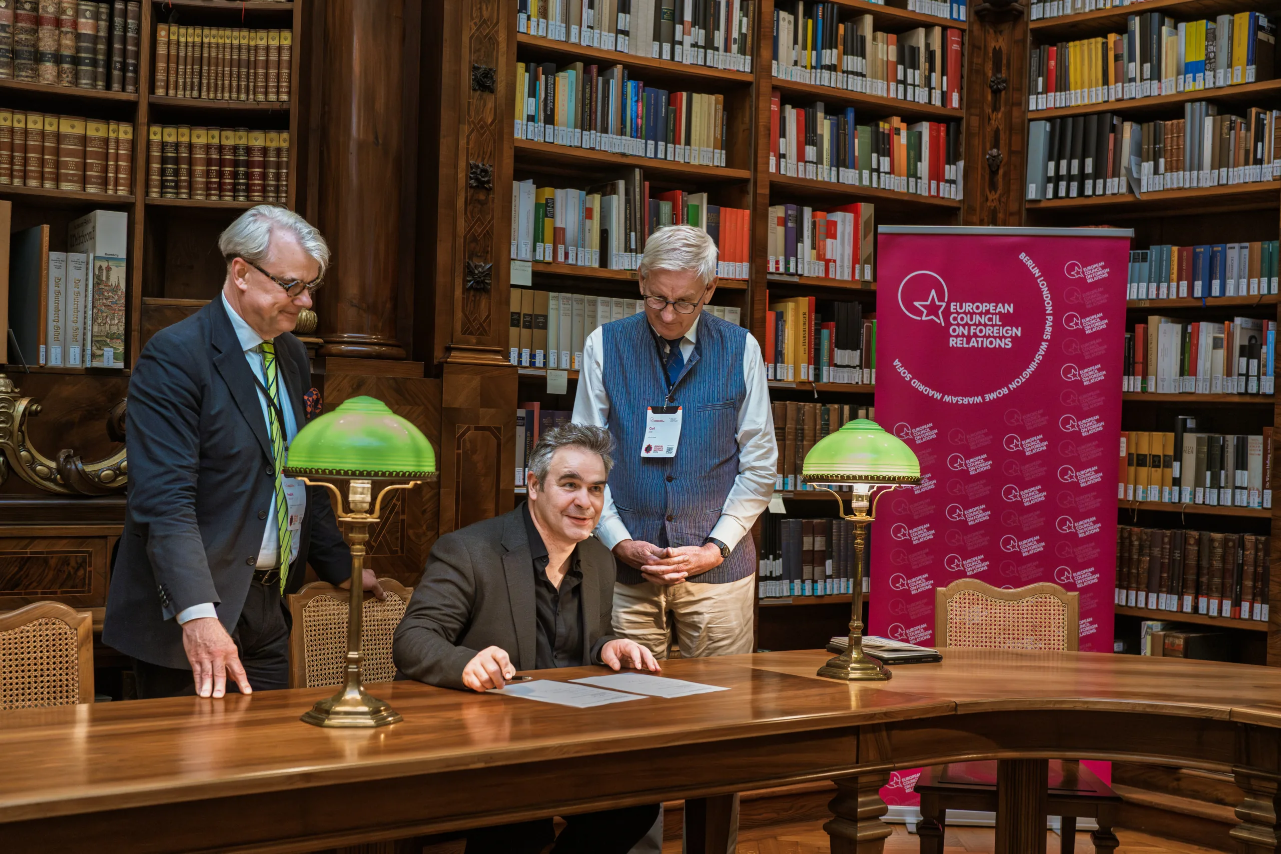 Officials signing a document in a historical library room at National Library in Vienna