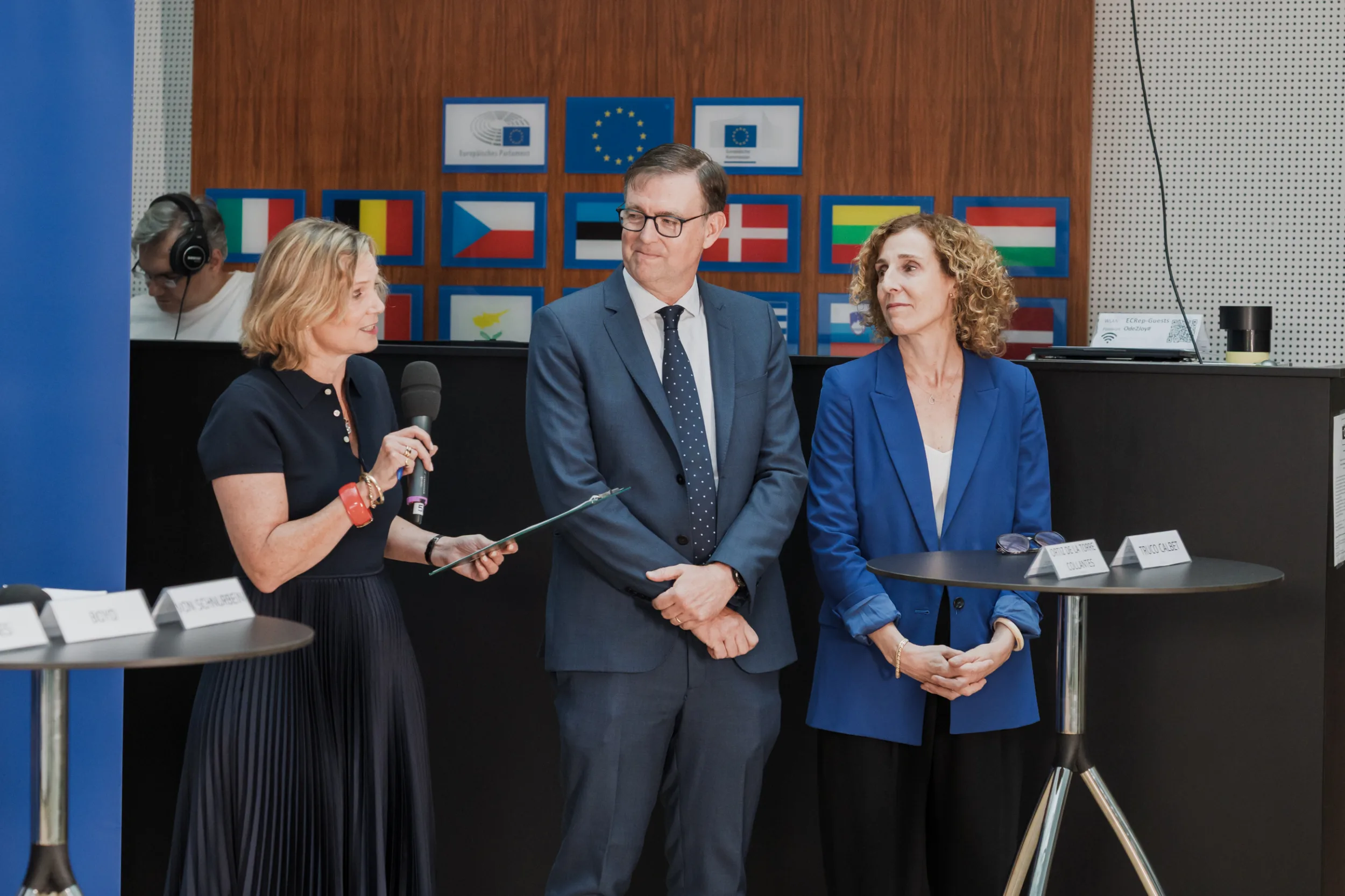 European Union Event Photographer | Grant Signing Ceremony in Vienna Fedor Vasilev Photographer In Berlin An event moderator and EU officials on stage in front of European flags in House of European Union in Vienna