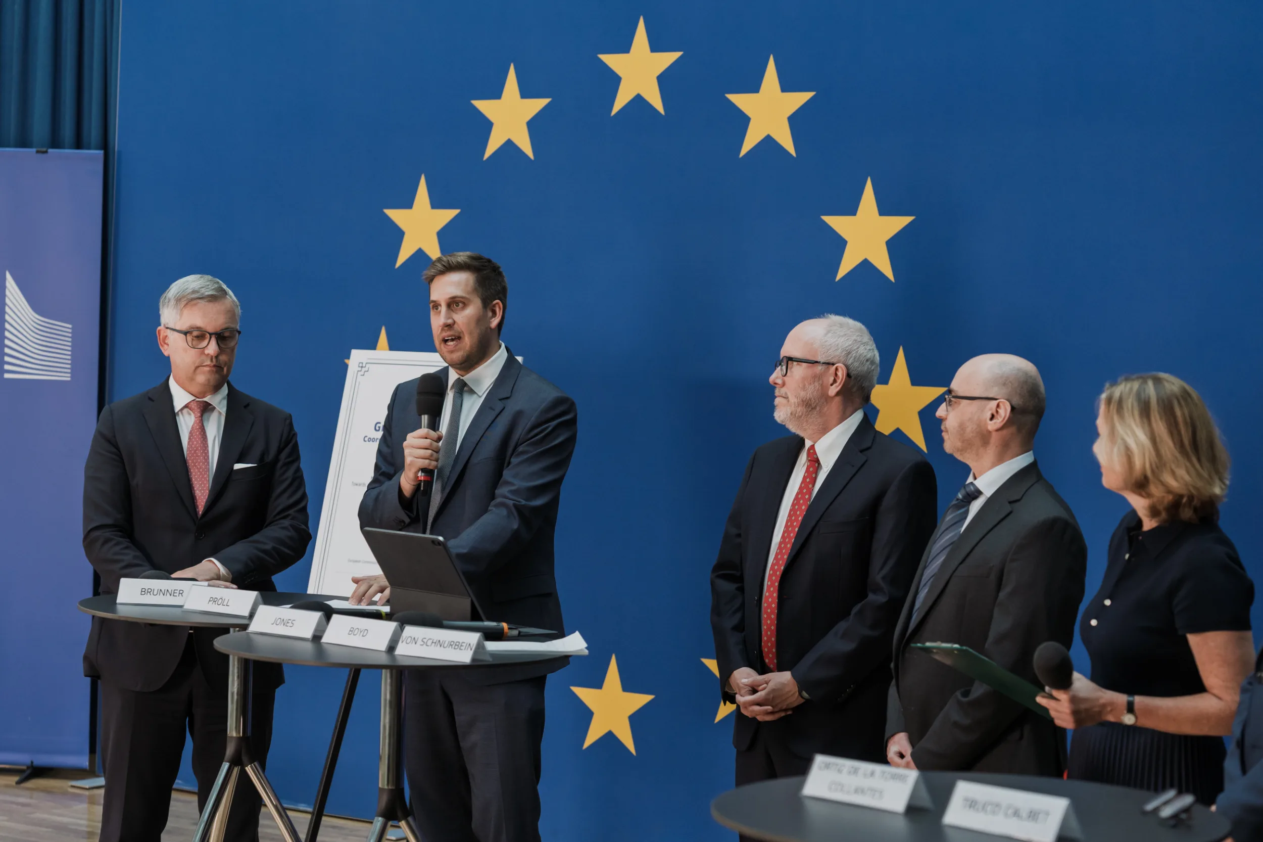 European Union Event Photographer | Grant Signing Ceremony in Vienna Fedor Vasilev Photographer In Berlin European official speaking in front of a blue background during a formal ceremony