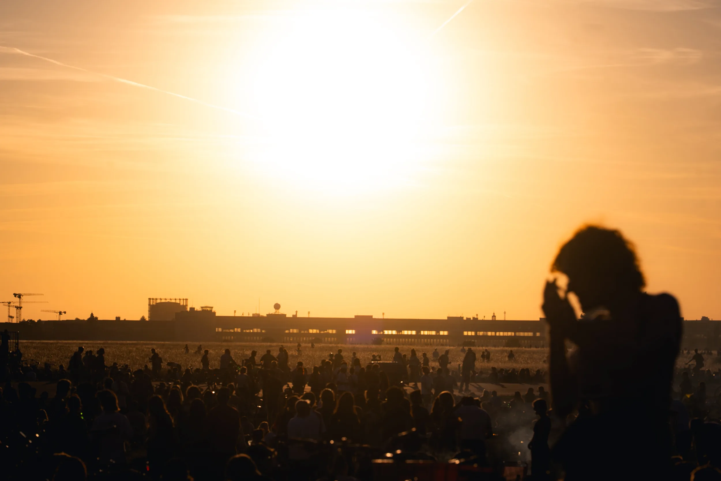 Photographing the Solar Eclipse in Berlin Fedor Vasilev Photographer In Berlin Crowd of people silhouetted against a bright orange sunset at Tempelhof Field in Berlin, captured by Fedor Vasilev.