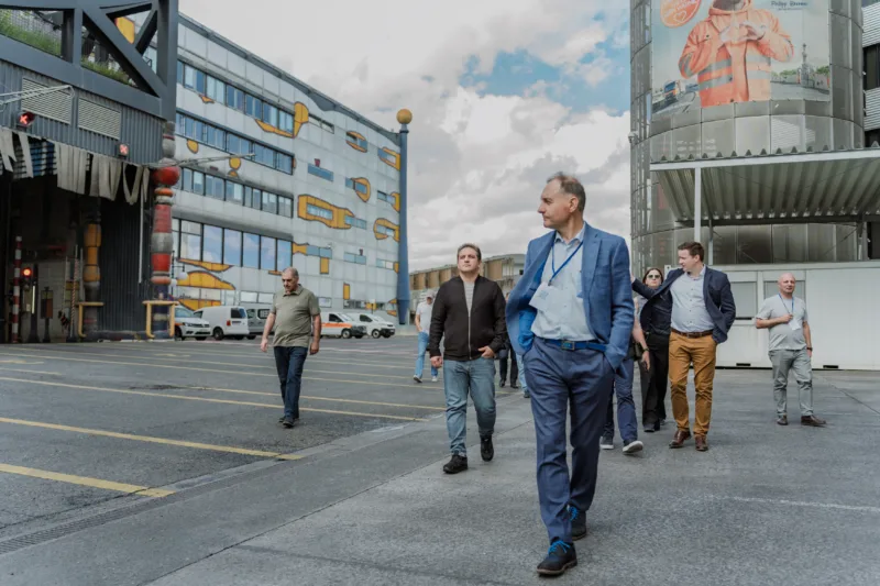 Delegates walk across an industrial courtyard near the colorful Spittelau waste incinerator in Berlin.
