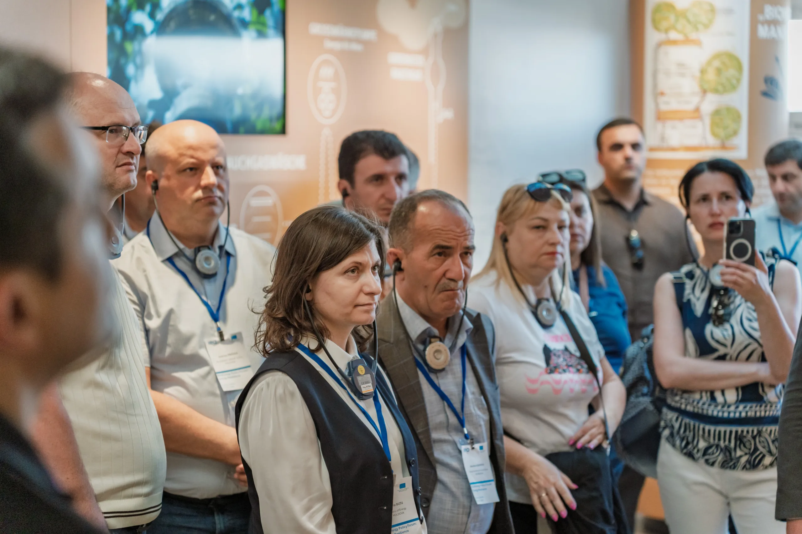 EU4Energy Conference Photography in Vienna Fedor Vasilev Photographer In Berlin Group of attendees wearing lanyards and headsets listening intently to a presentation during an EU4Energy event.