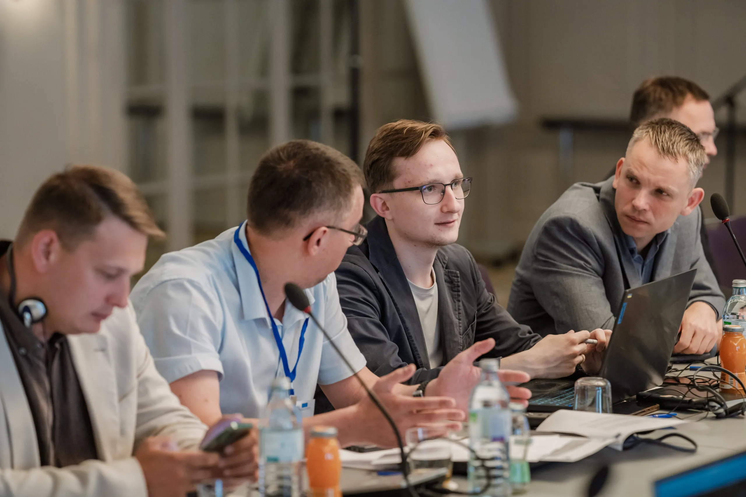 EU4Energy Conference Photography in Vienna Fedor Vasilev Photographer In Berlin Young man with glasses listens intently as a colleague speaks during an EU4Energy conference roundtable discussion.